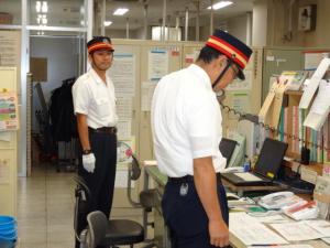 駅職員が各関係先へ通報している写真