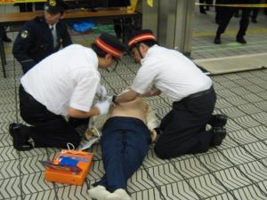 駅職員が心肺停止状態のお客さまにAEDを使用している写真