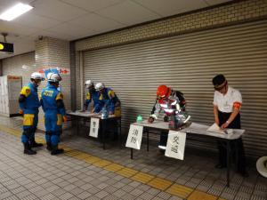 駅職員が消防士に状況報告している写真